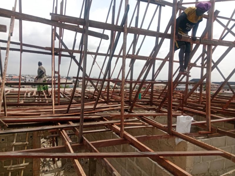 Workers fixing a steel roof frame