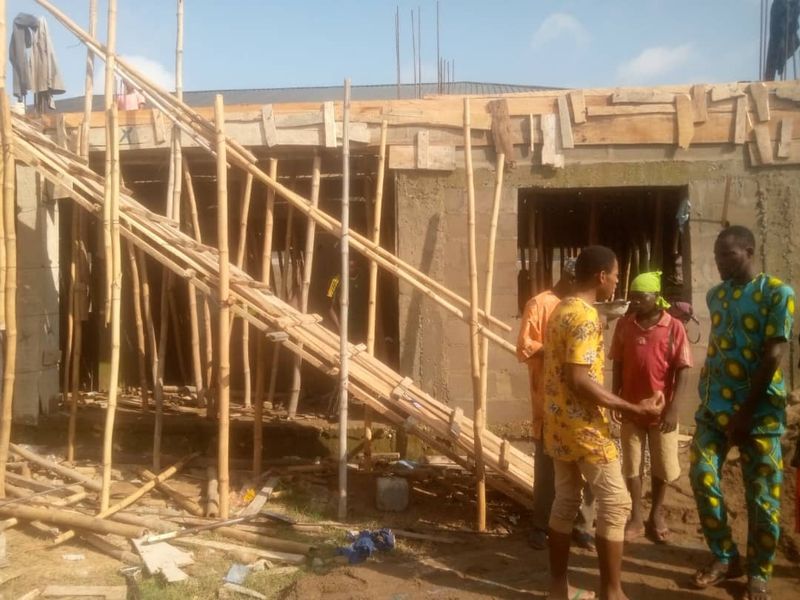 Three people talking in front of a building under construction