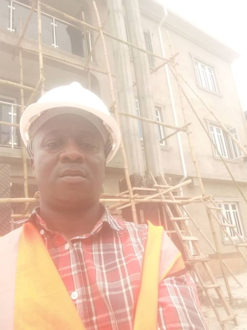Team member in a hard hat in front of scaffolding